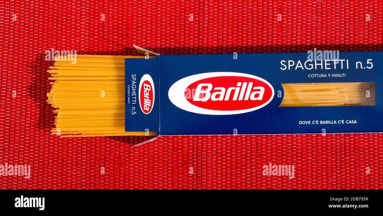 Pacchetto aperto di Barilla Spaghetti pasta in confezione al dettaglio visto in alto su uno sfondo tessile rosso Foto Stock