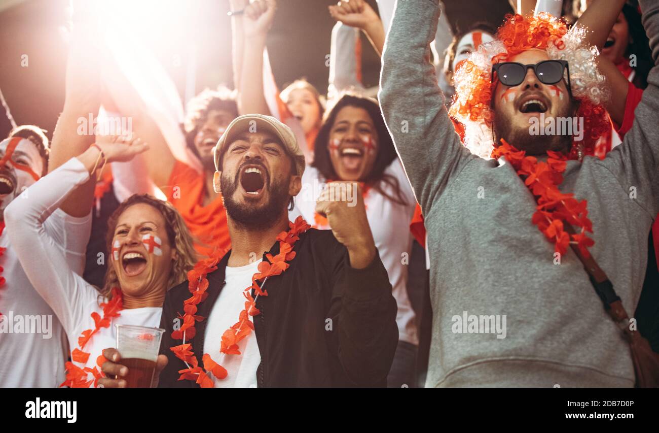 Gli appassionati di calcio inglesi celebrano la vittoria della loro squadra. Inghilterra tifosi di calcio godendo dopo una vittoria allo stadio. Foto Stock