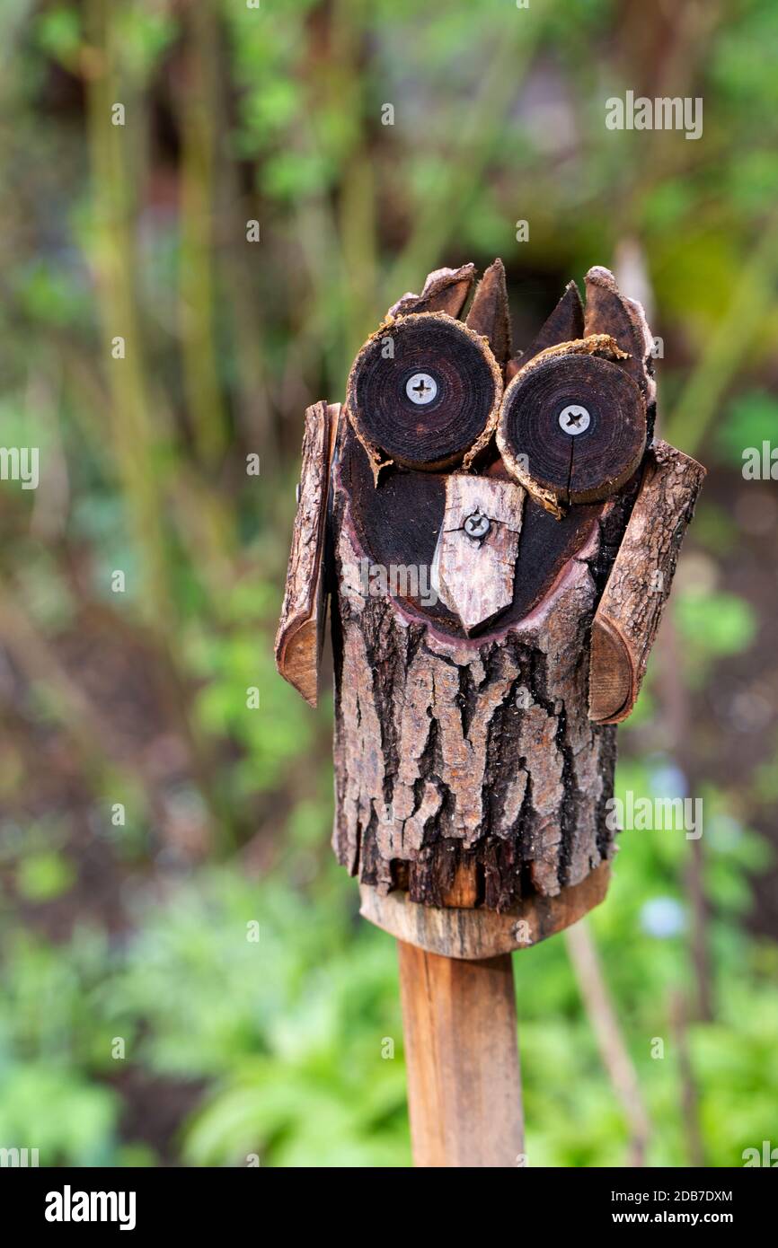 gufo di legno su palo in un giardino di campagna Foto Stock