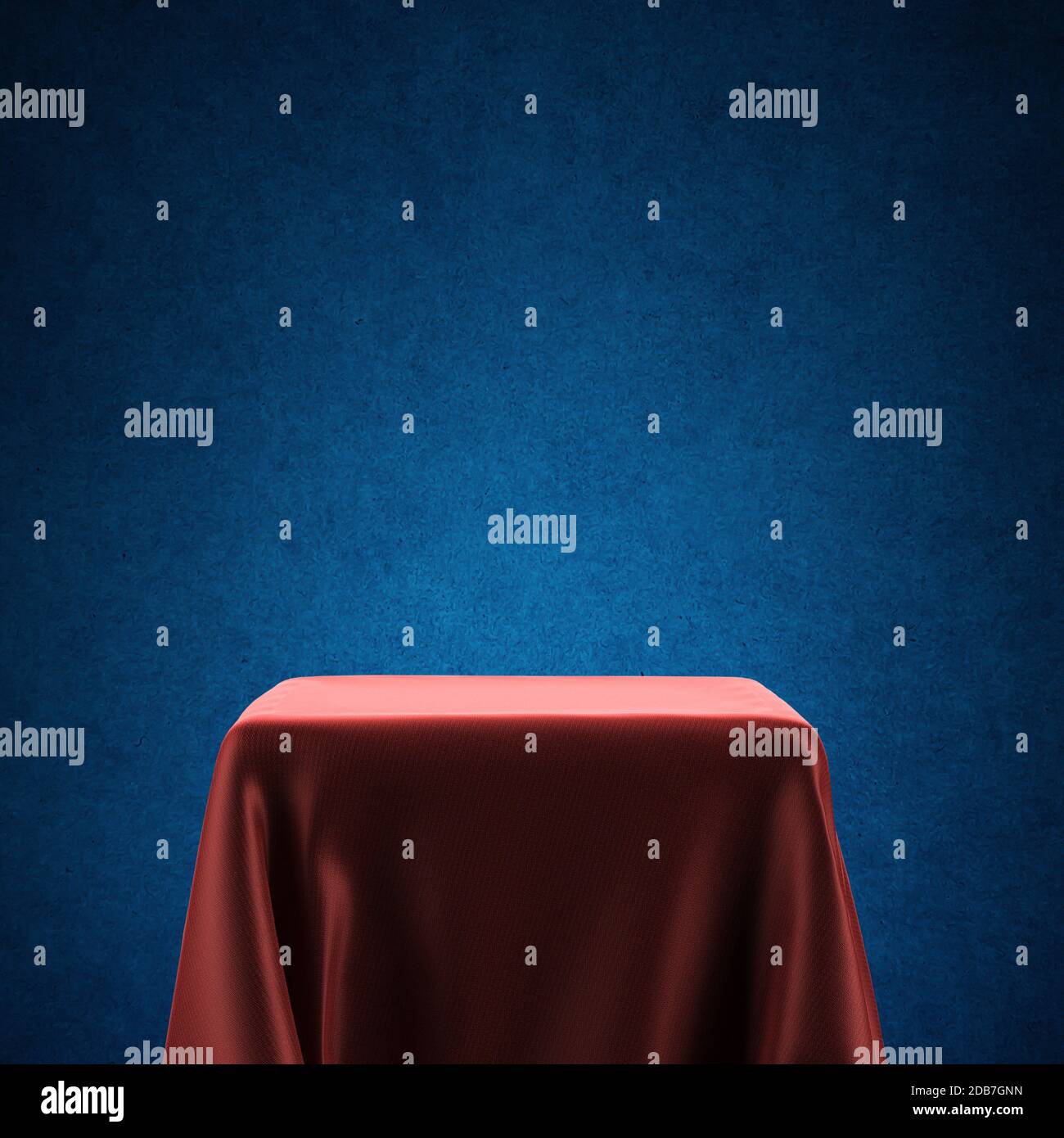 Piedistallo vuoto del faretto coperto con panno rosso su sfondo blu retroilluminato Foto Stock