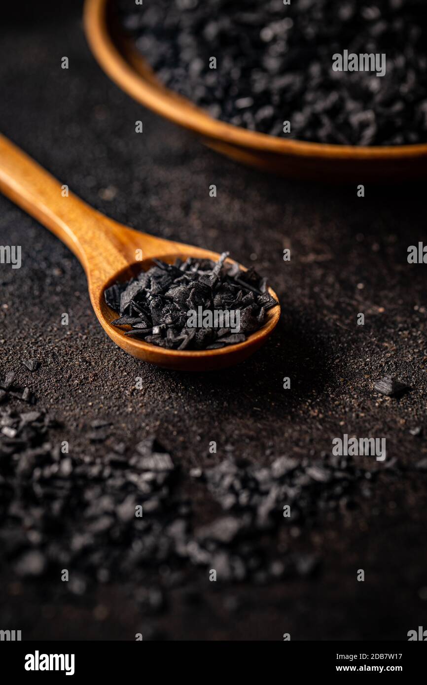 Sale marino colorato nero dalla lava vulcanica e mescolato con carbone disattivato su sfondo scuro Foto Stock