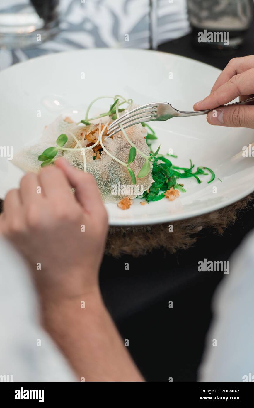 Donna che mangia insalata di Calamari croccante con lattuga, limone e asparagi Foto Stock