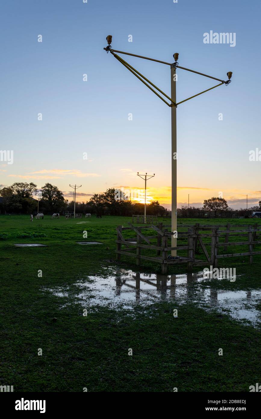 Atterraggio avvicinarsi luci in un campo sotto l'approccio all'aeroporto di Londra Heathrow, Regno Unito, all'alba su cielo chiaro mattina d'autunno. Luce del mattino presto Foto Stock