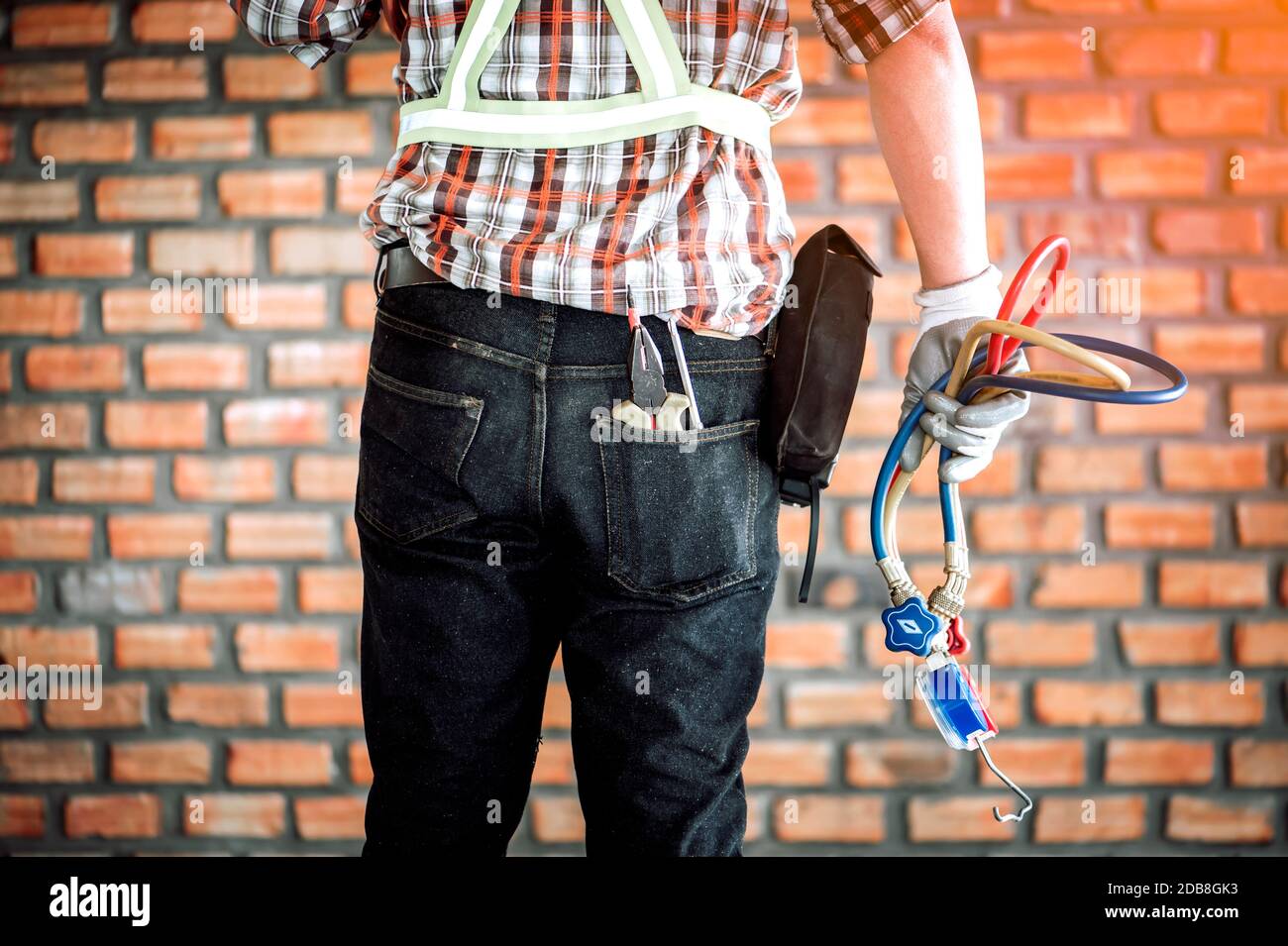 Vista posteriore di un operatore manuale con attrezzi, Thailandia Foto Stock