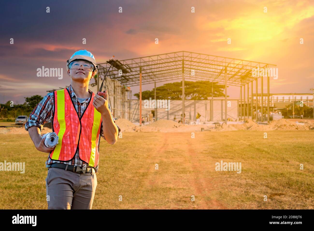 Lavoratore di costruzione in piedi di fronte al cantiere, Thailandia Foto Stock