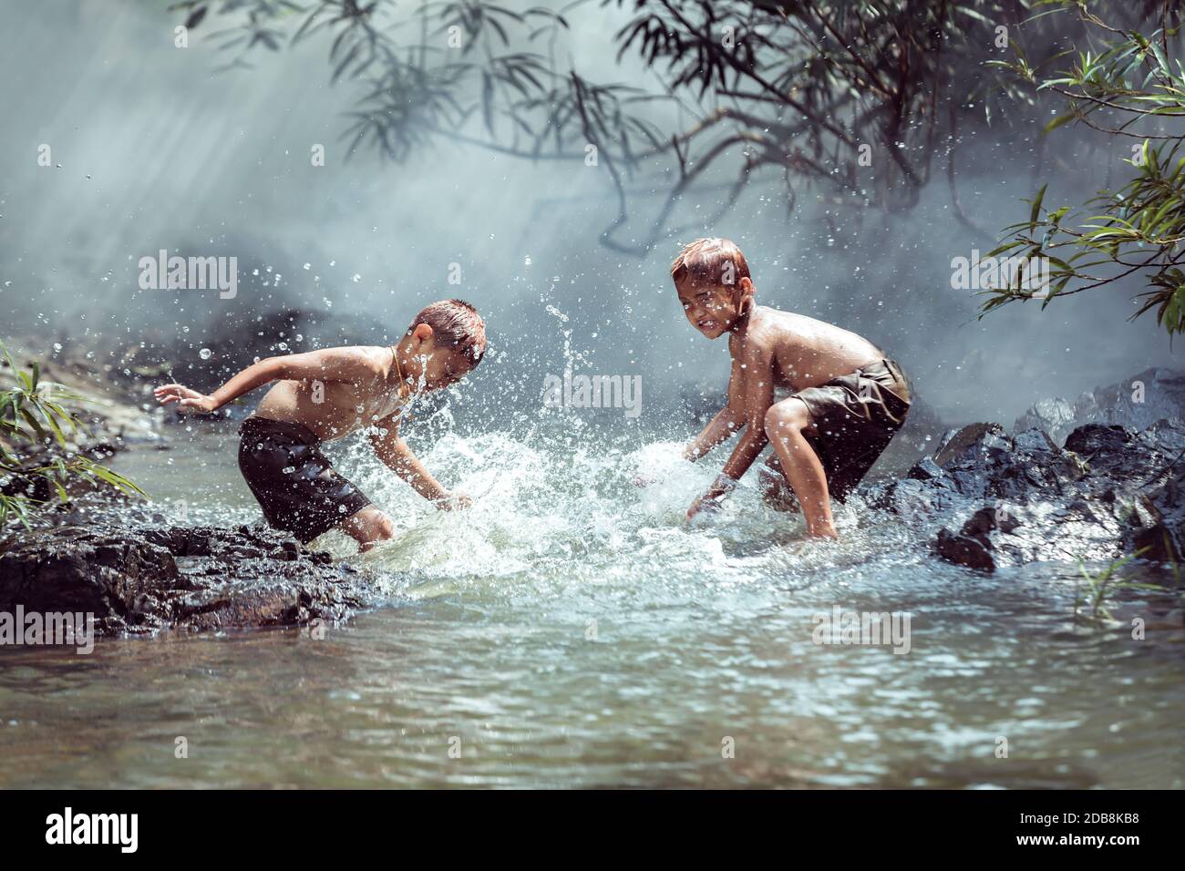 Due ragazzi che si lavano in un fiume, Thailandia Foto Stock