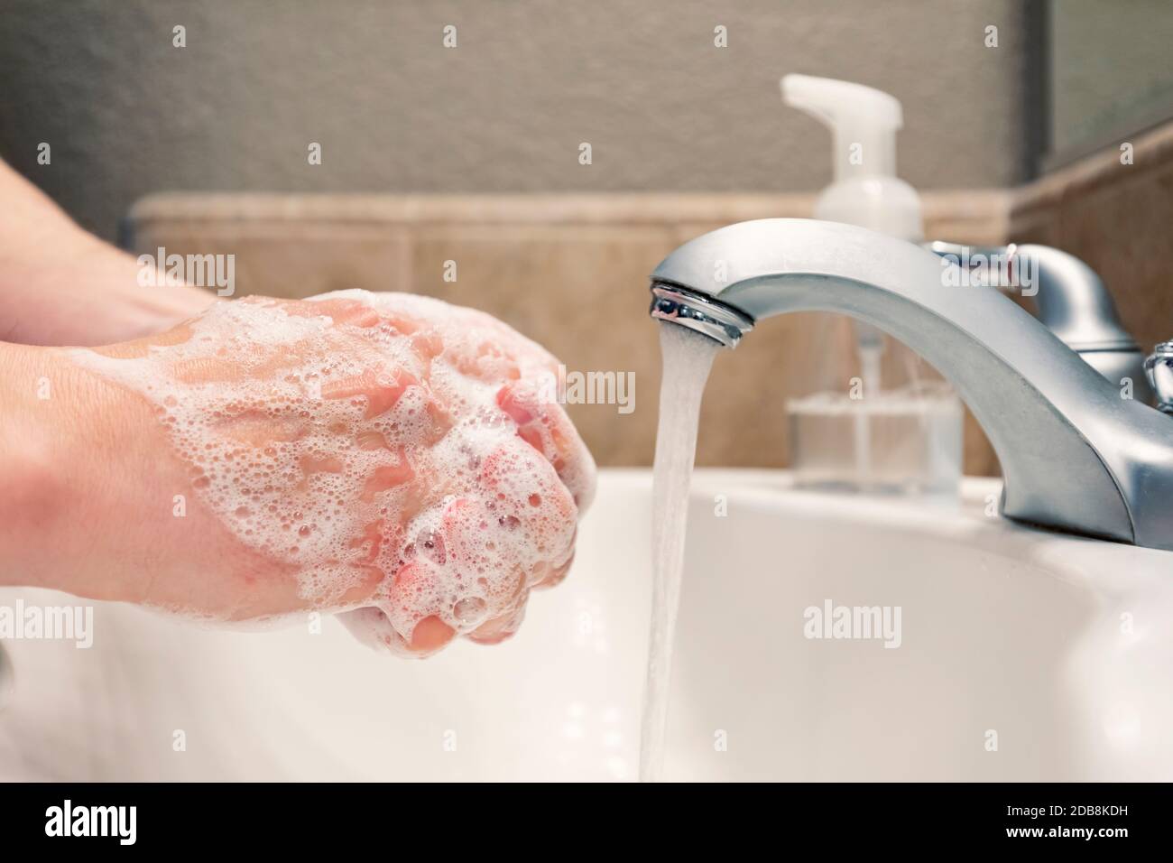 Lavando le mani con sapone e acqua nel lavello del bagno, protezione contro i virus influenzali del coronavirus covid-19, igiene per rimanere in buona salute Foto Stock
