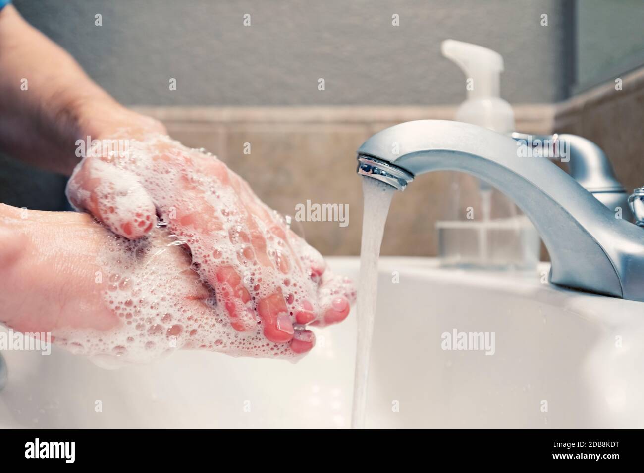 Lavando le mani con sapone e acqua nel lavello del bagno, protezione contro i virus influenzali del coronavirus covid-19, igiene per rimanere in buona salute Foto Stock