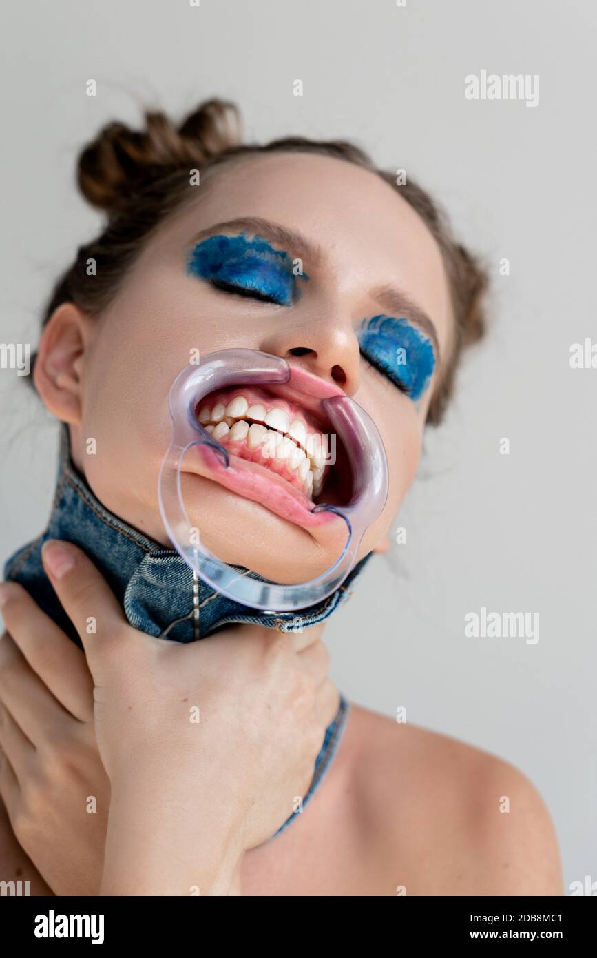 Ritratto di una donna che indossa un divaricatore dentale della bocca  soffocante lei stessa Foto stock - Alamy