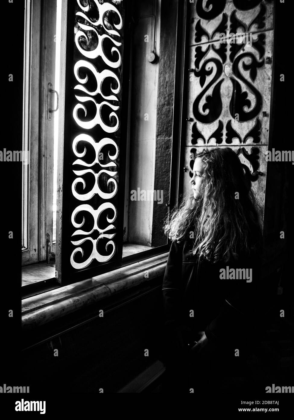 Ritratto di una ragazza che guarda fuori da una finestra Foto Stock