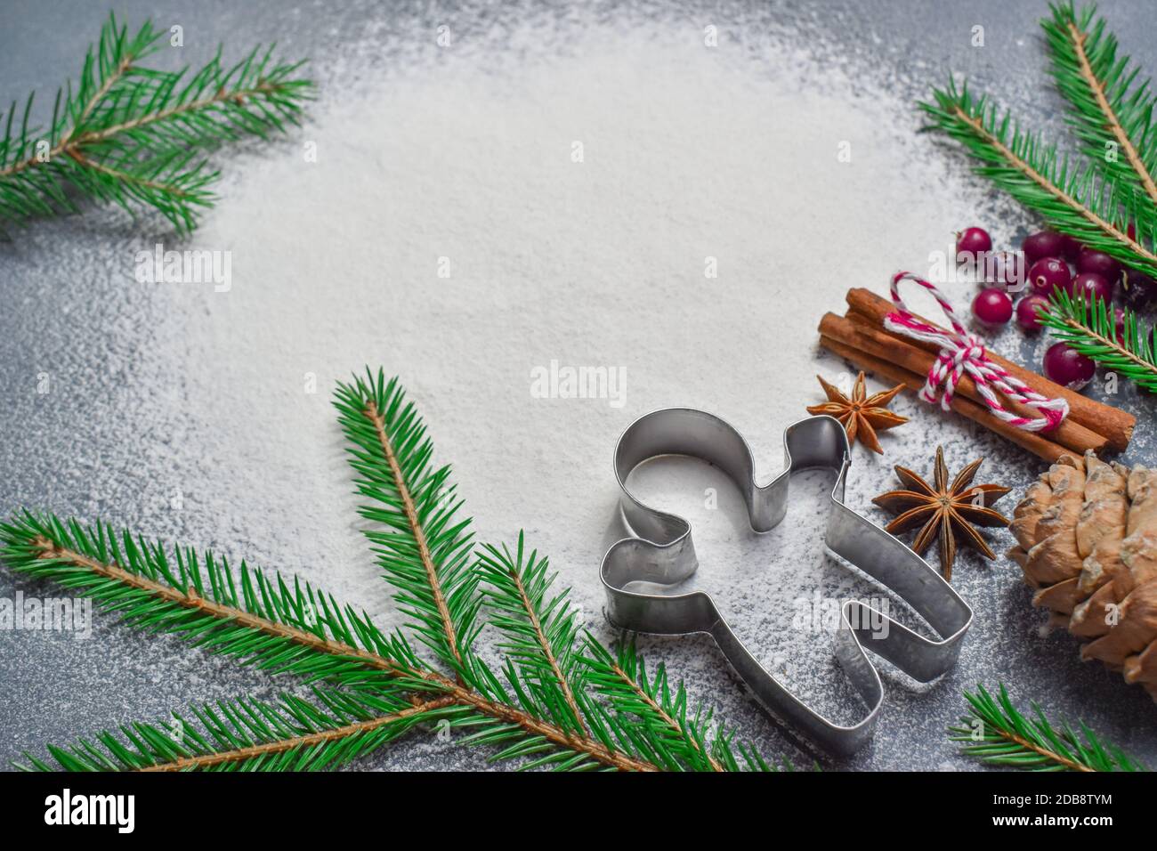 Minimalismo. Sfondo di Natale con una taglierina tagliente del biscotto e un ramo dell'albero ha un posto per il testo. Layout piatto vista dall'alto Foto Stock