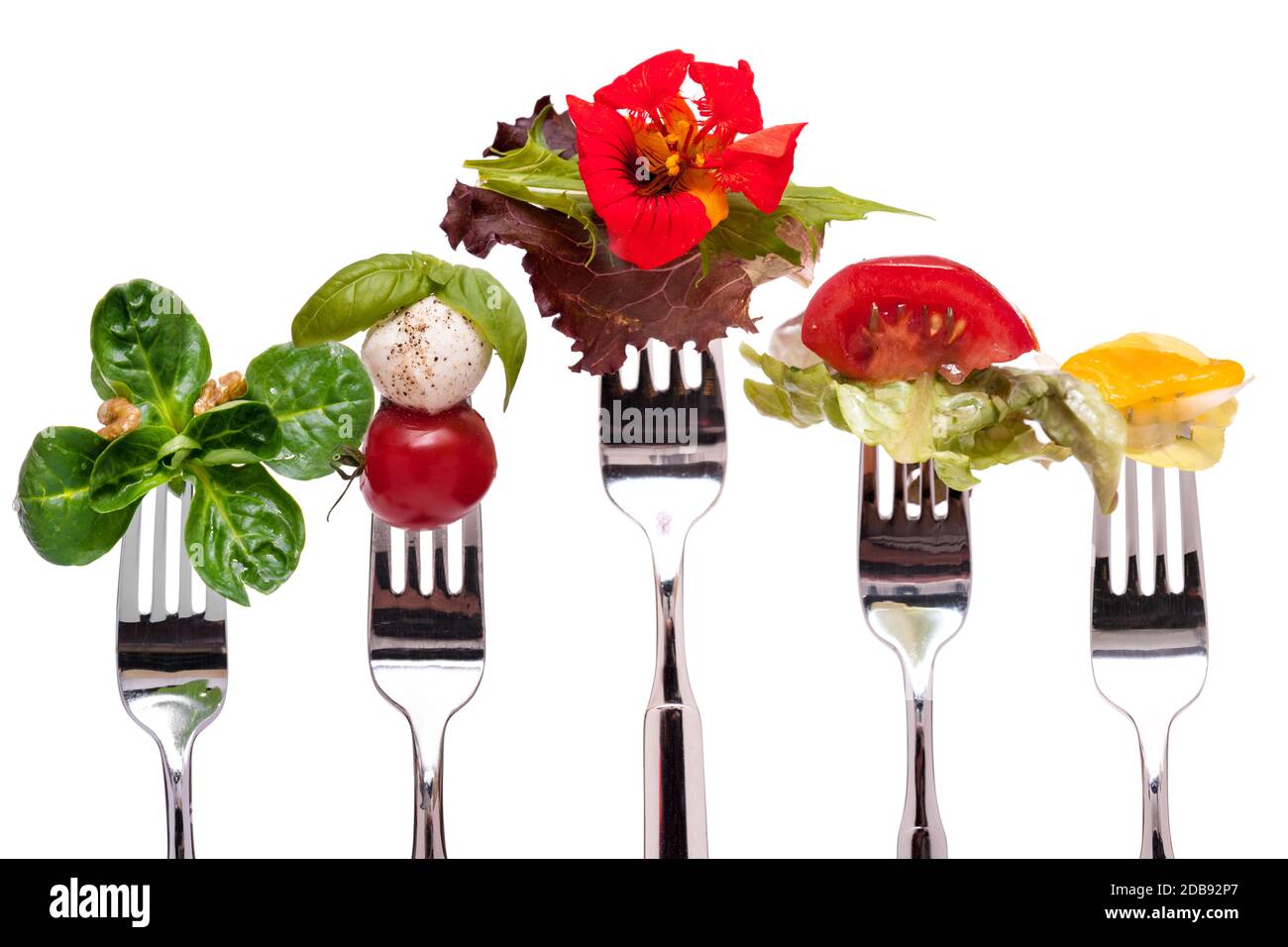 Insalata diversa su una forchetta bianca isolato Foto Stock