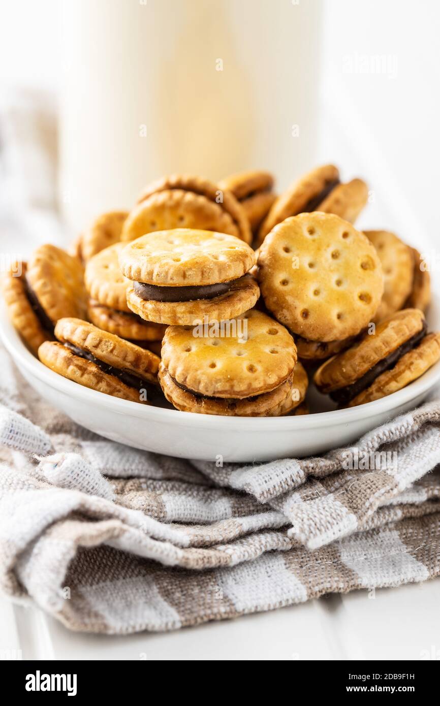 Mini biscotti panna sandwich in ciotola su tavolo bianco. Foto Stock