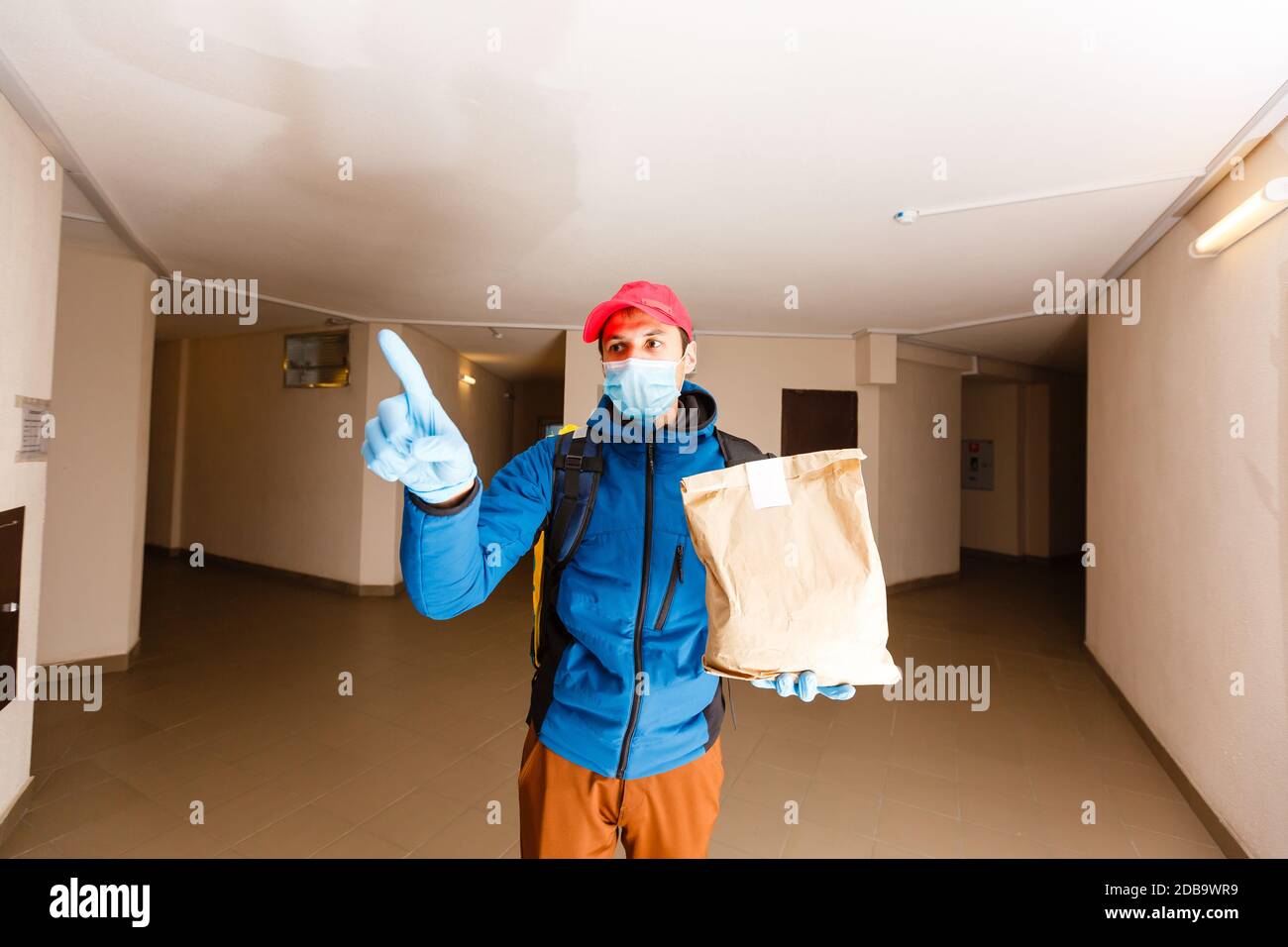 consegna uomo inviare sacchetto di cibo alla manopola della porta per contatto senza contatto o dal pilota di consegna in casa anteriore per la distanza sociale per rischio di infezione. Foto Stock