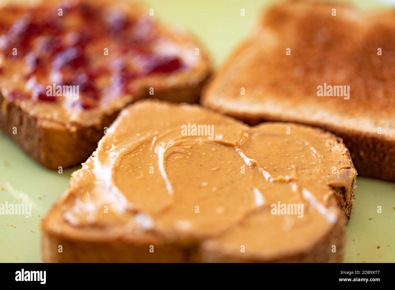 Fette di pane di grano integrale tostate con burro di arachidi e gelatina Foto Stock
