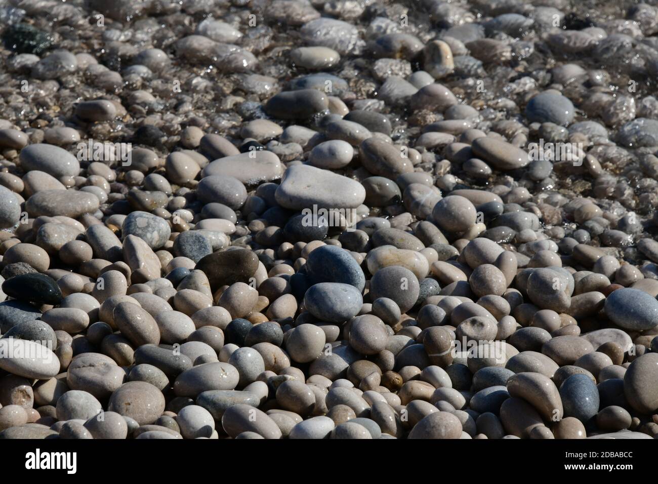 Pietre grandi, piccole, rotonde sulla spiaggia mediterranea in provincia di Alicante, Spagna Foto Stock