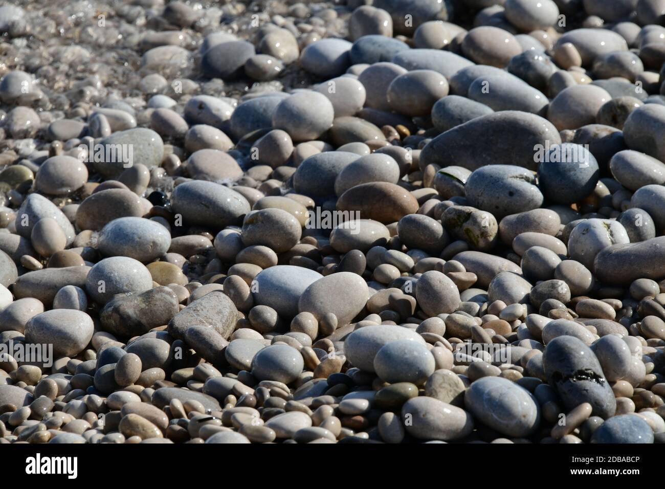 Pietre grandi, piccole, rotonde sulla spiaggia mediterranea in provincia di Alicante, Spagna Foto Stock