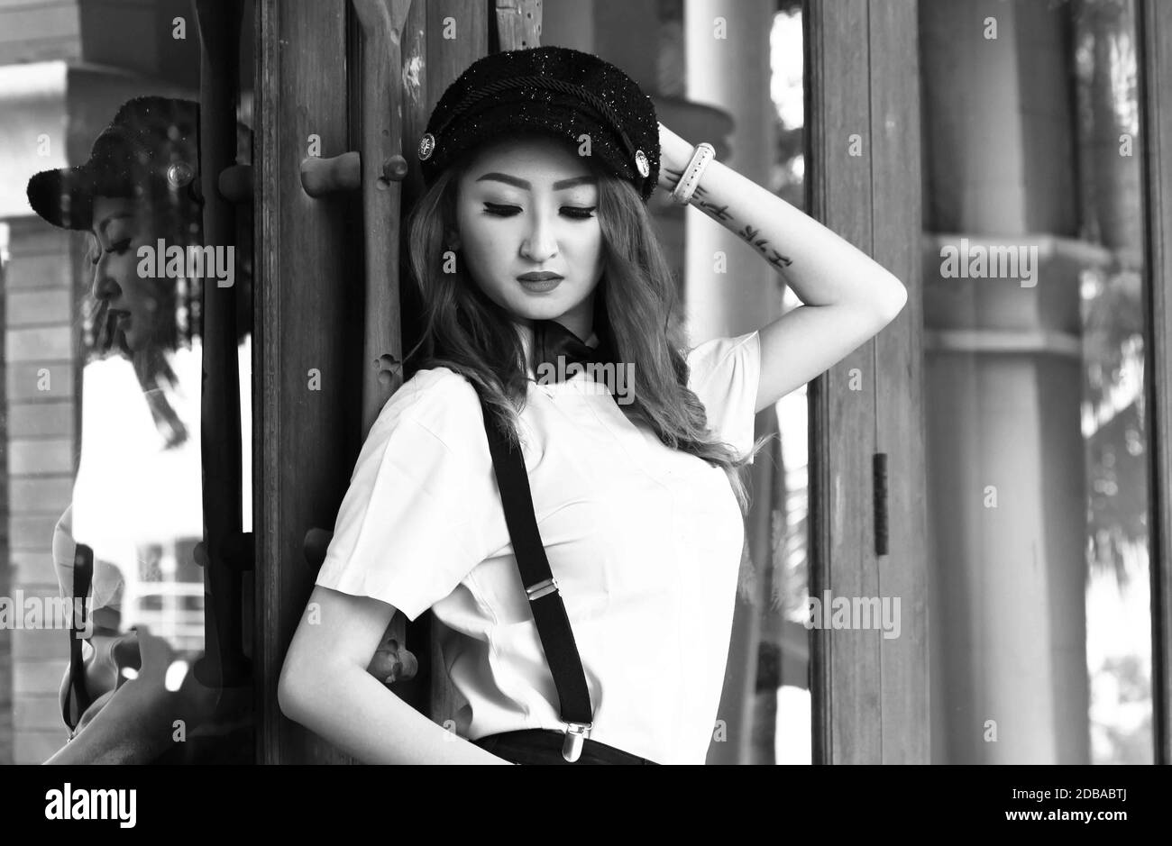 Un colpo medio bianco e nero di una donna indonesiana che guarda verso il basso. Foto Stock