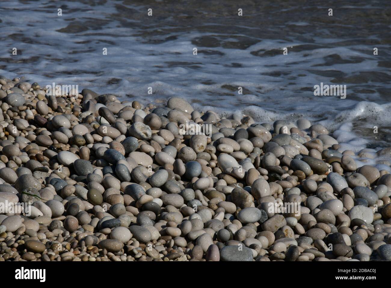 Pietre grandi, piccole, rotonde sulla spiaggia mediterranea in provincia di Alicante, Spagna Foto Stock