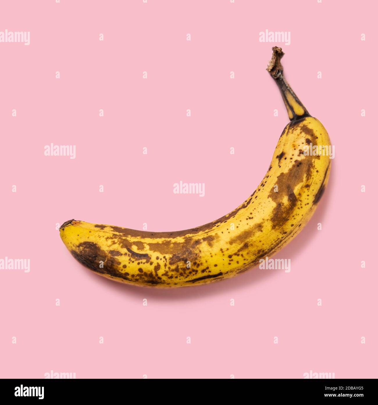 Banana soprammatura su sfondo rosa Foto Stock
