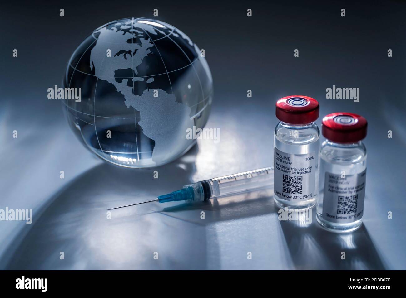 Globo di vetro e siringa con vaccino su sfondo grigio Foto Stock