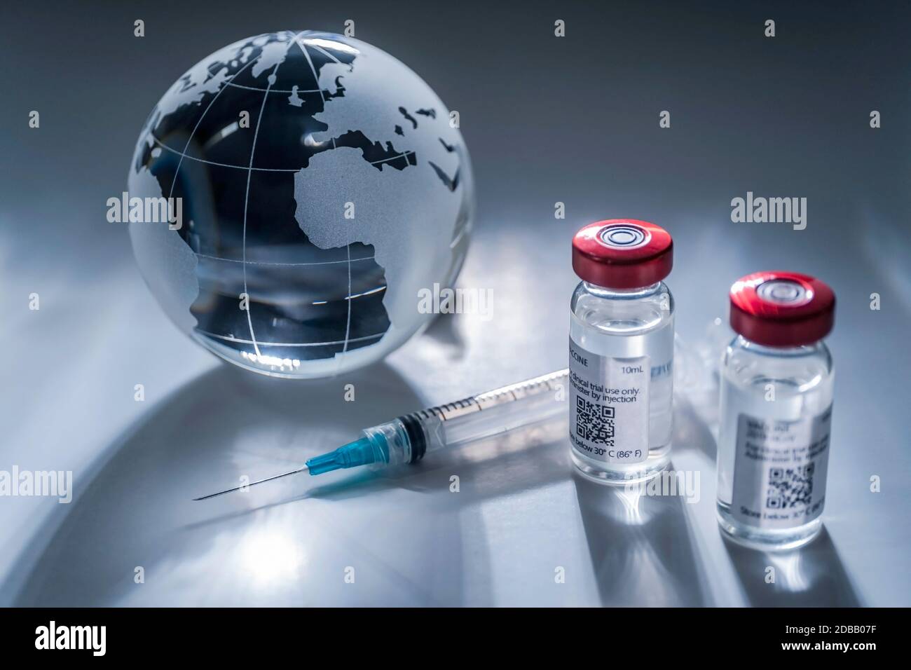 Globo di vetro e siringa con vaccino su sfondo grigio Foto Stock