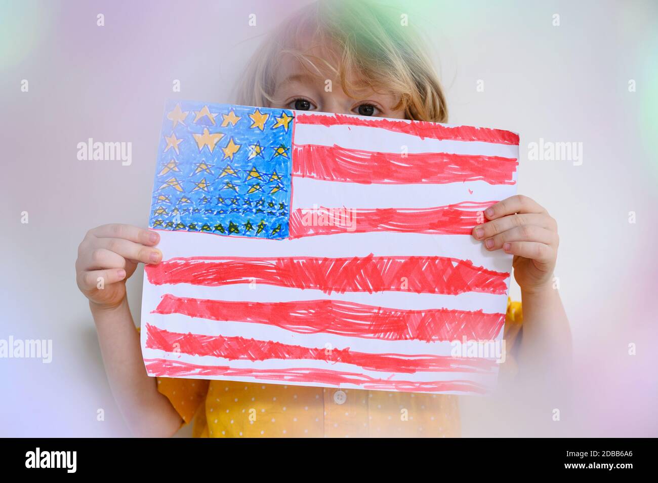 Ragazzo (4-5) che mostra la bandiera americana disegnata su carta Foto Stock