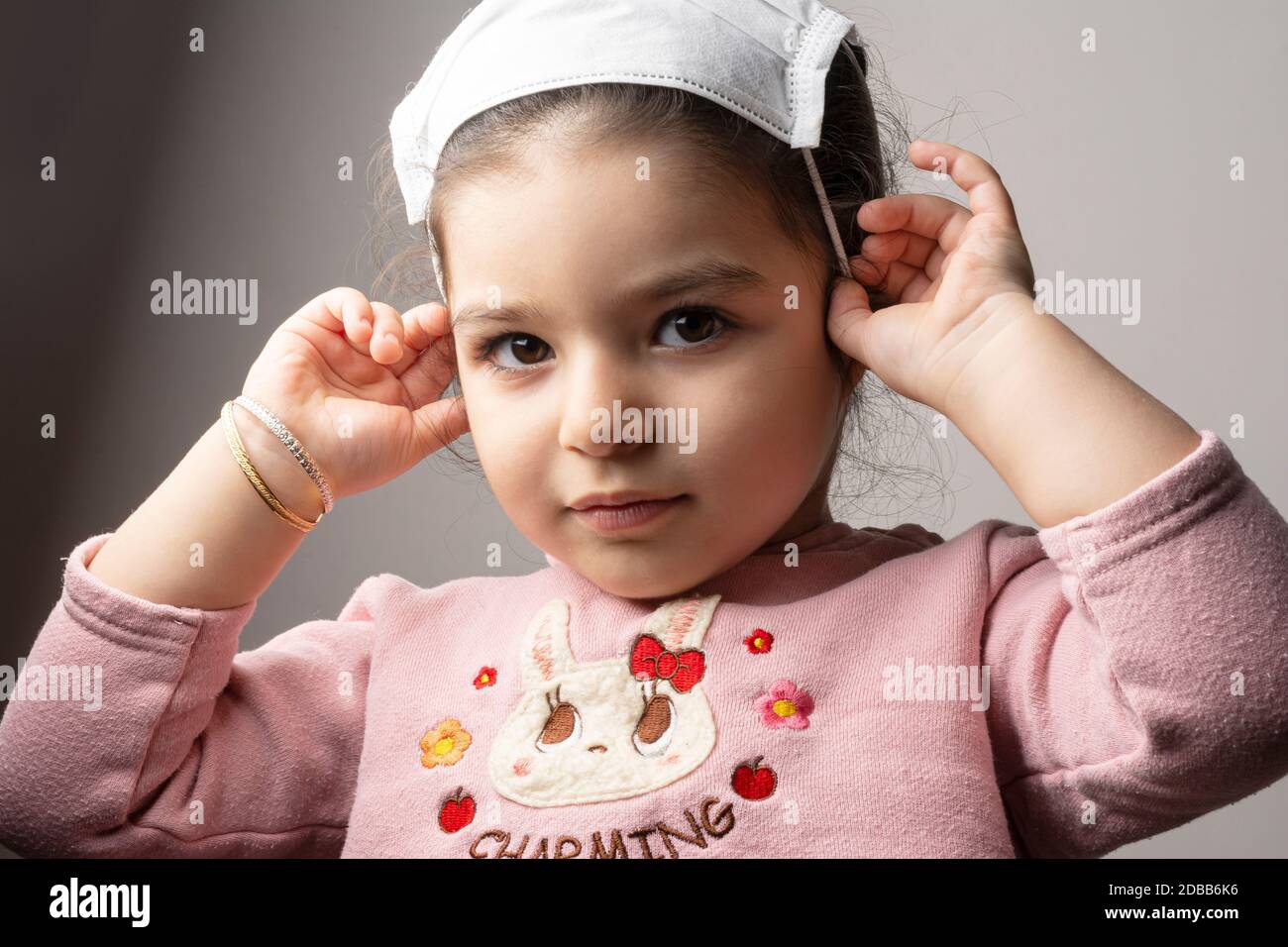 Ritratto della bambina con maschera medica sulla sua testa, epidemia di coronavirus epidemico concetto Foto Stock