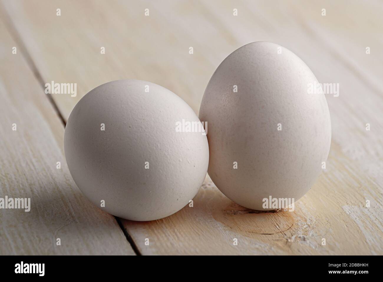 Due uova bianche su un tavolo di legno bianco Foto Stock