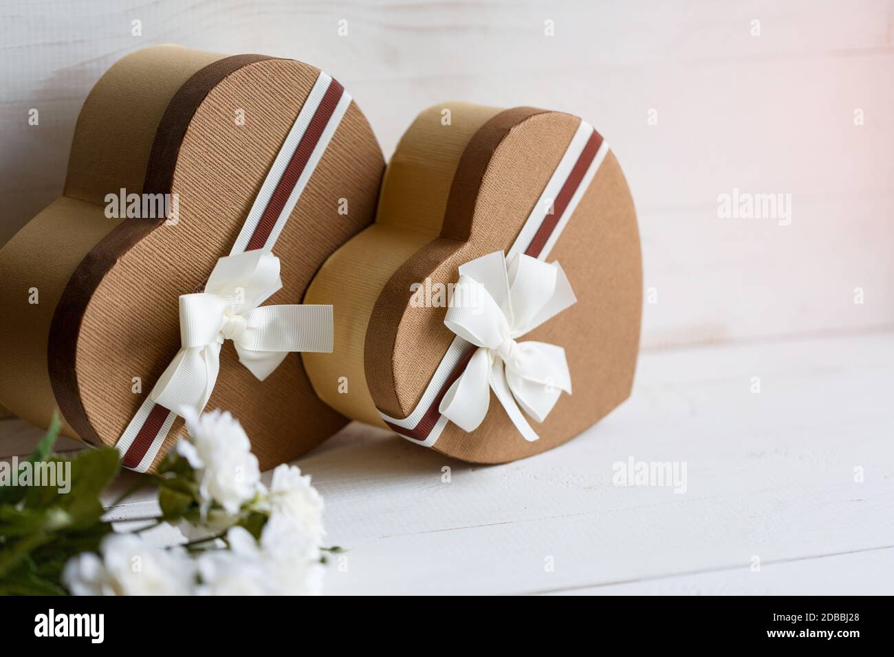 Concetto di storie d'amore e per San Valentino due scatole regalo a forma di cuore su sfondo bianco. Vista laterale. Inserire il testo. Foto Stock