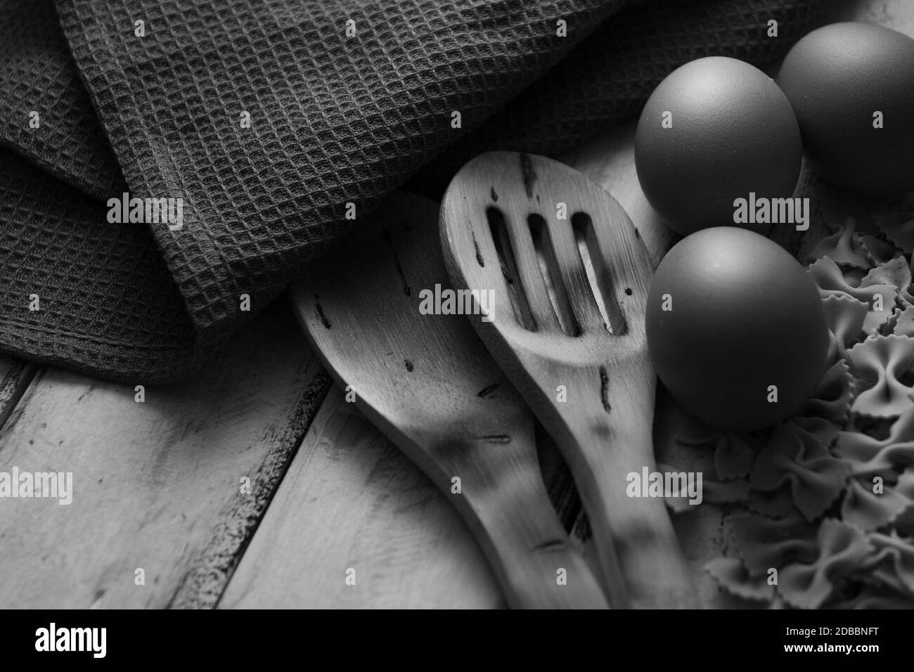 pasta secca su legno rustico e uova fresche in bianco e nero Foto Stock