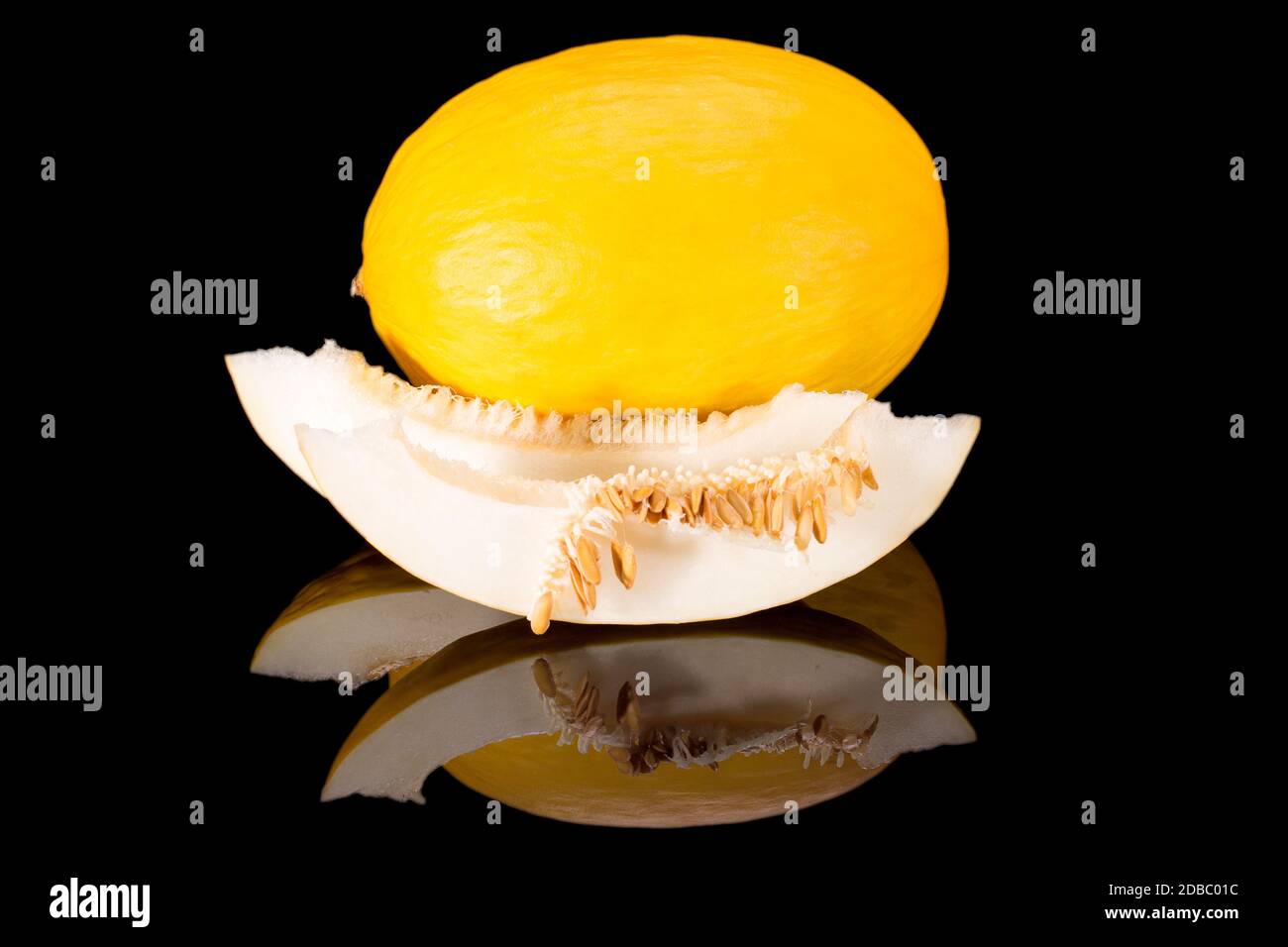 Big singolo frutta intera e tagliata di melone giallo miele isolato su sfondo nero, primo piano Foto Stock