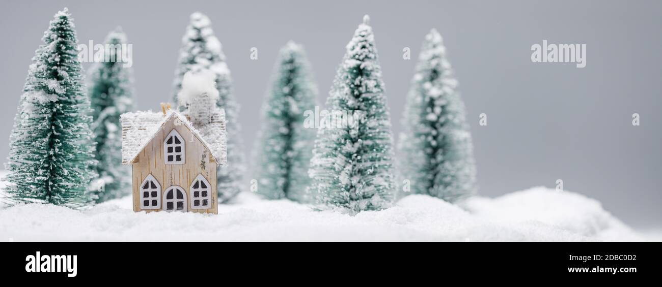 Carta di Natale e Capodanno, casa giocattolo nella neve nella foresta di abeti. Vacanze invernali e concetto di celebrazione. Foto Stock