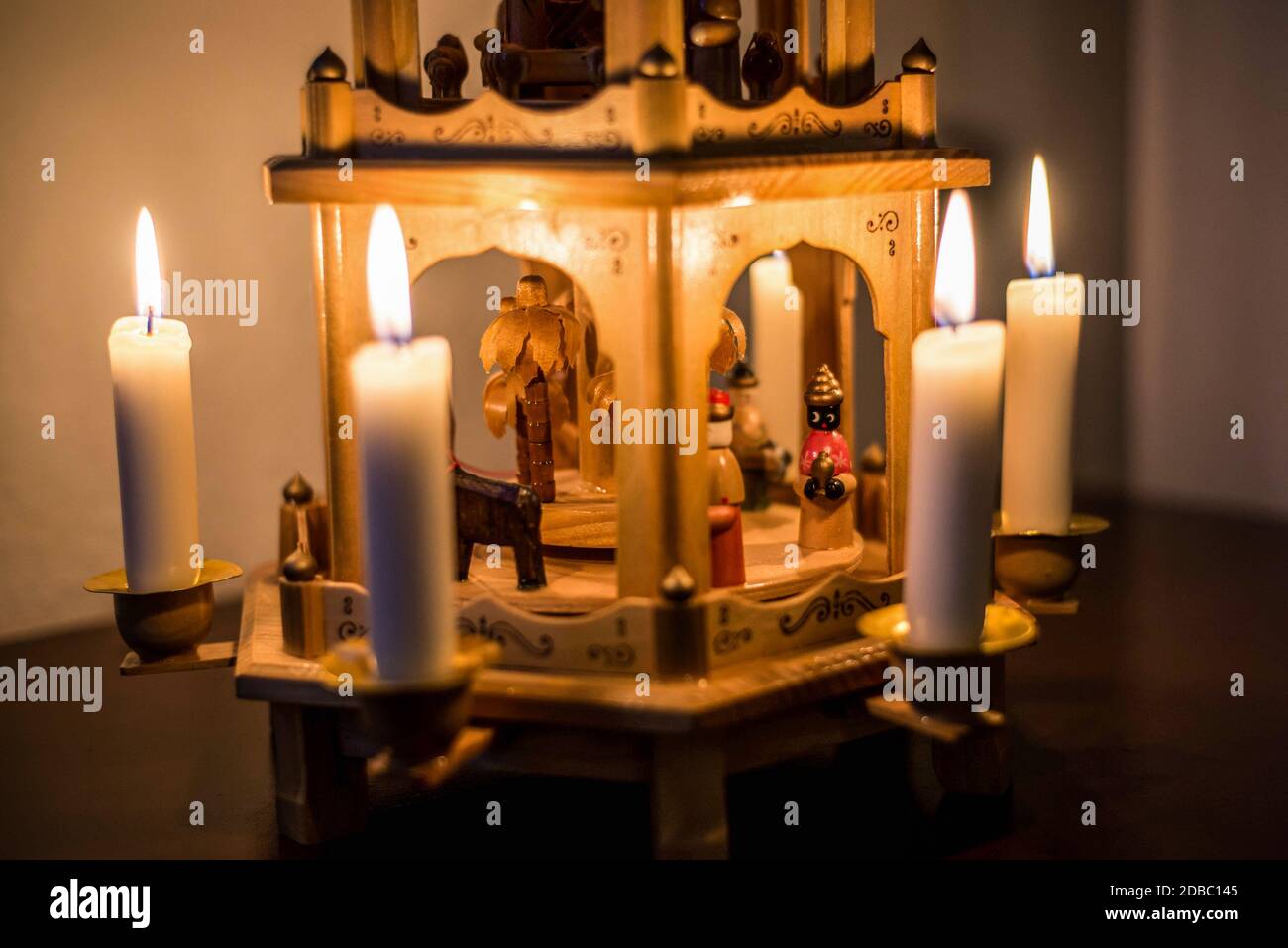 Decorazioni natalizie tradizionali. Candele che bruciano su una giostra di  Natale in legno con presepio e sculture in legno di personaggi natalizi  Foto stock - Alamy