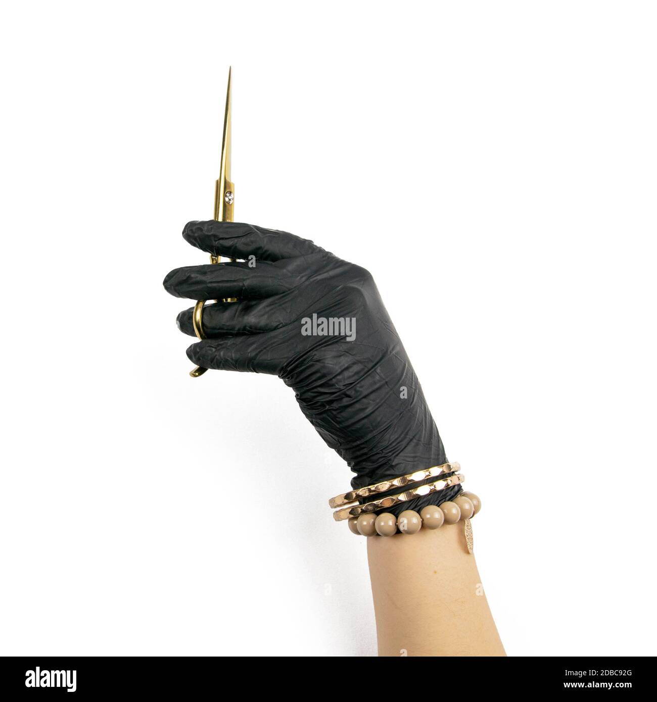 Mano con guanti che tiene uno scisor d'oro su uno sfondo bianco isolato  Foto stock - Alamy