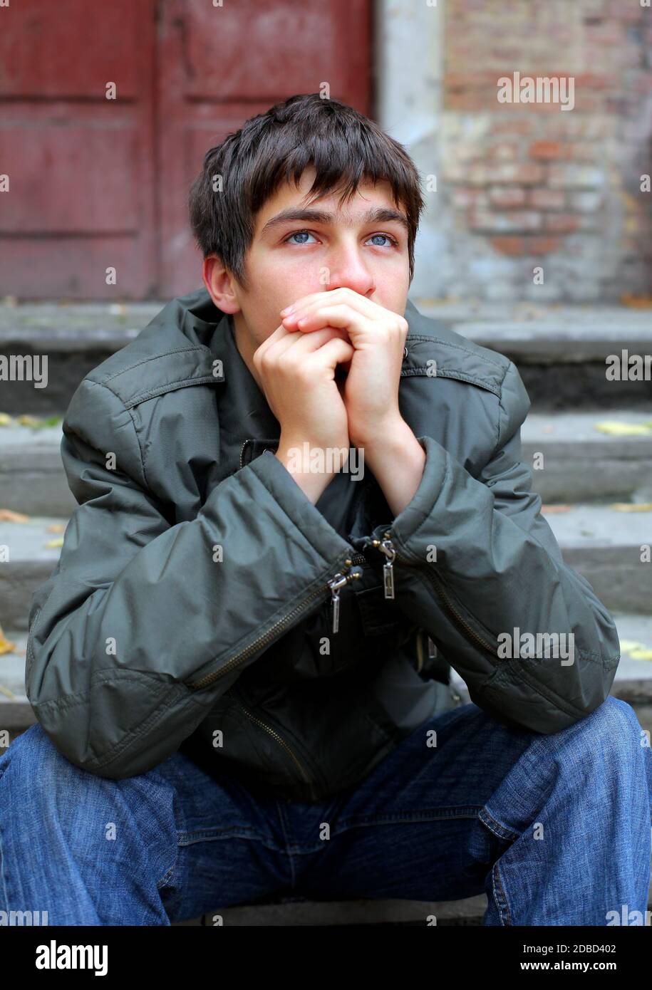 Triste giovane uomo Ritratto sulla vecchia casa sfondo Foto Stock