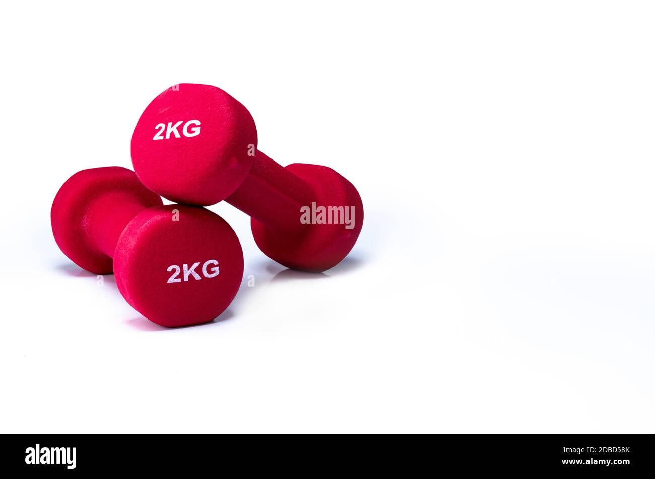 Set di manubri rossi isolati su sfondo bianco. Un paio di manubri in neoprene rosso. Attrezzatura home gym per l'esercizio fisico a casa. Attrezzature per l'allenamento del peso Foto Stock