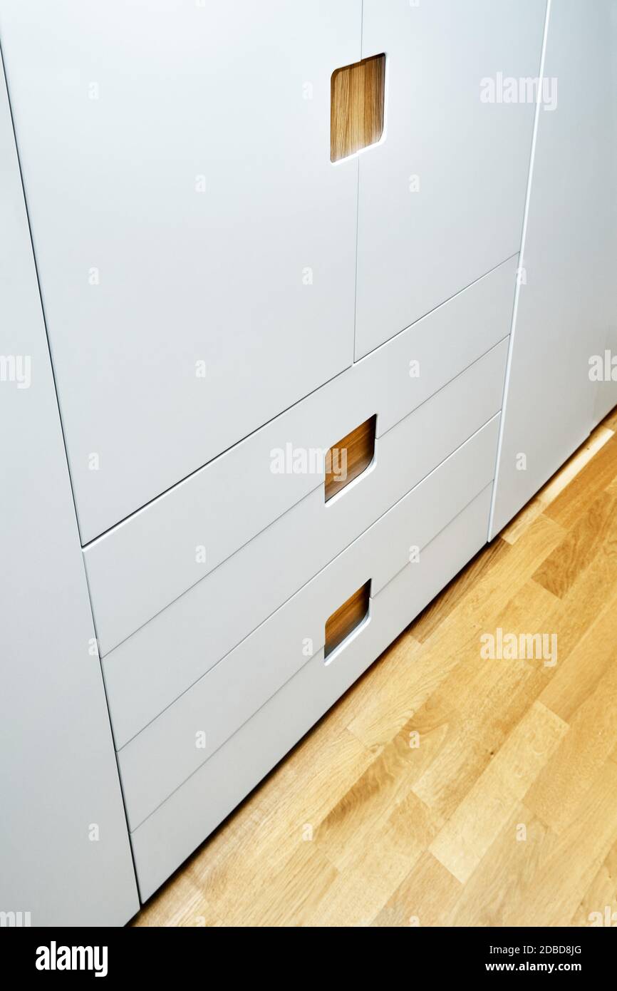 moderno armadio in legno con porte armadio a scomparsa. Mobili in legno compensato di quercia con ante verniciate grigio chiaro. Arredamento moderno Foto Stock