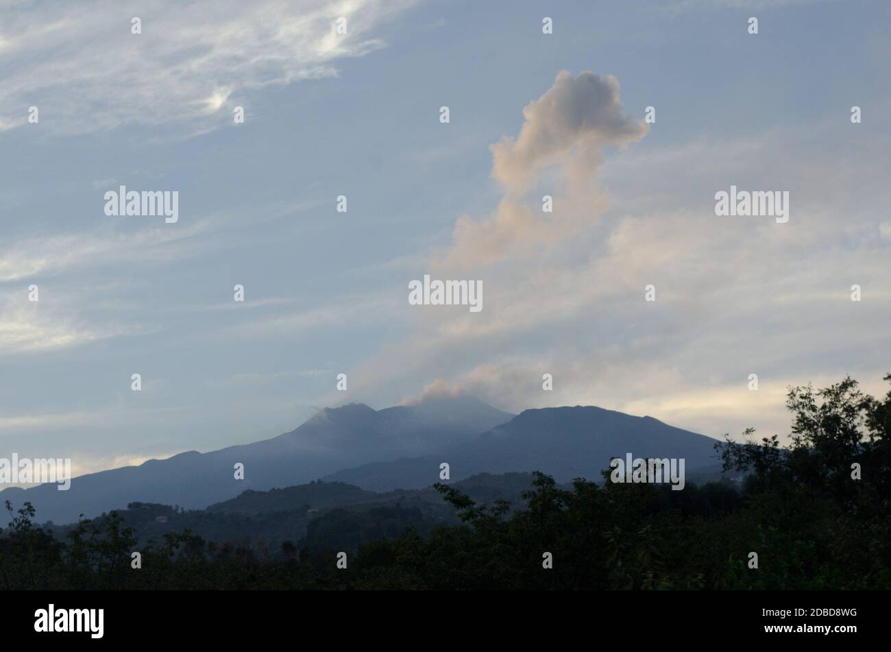 Nuvole og fumo vulcanico passando sopra il Monte Etna pendii e colline in Sicilia, Italia. Foto Stock