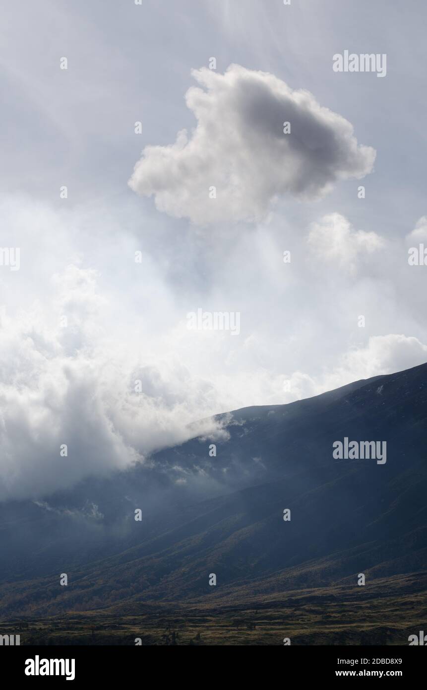 Nuvole di fumo vulcanico che attraversano le pendici e le colline dell'Etna in Sicilia, Italia Foto Stock