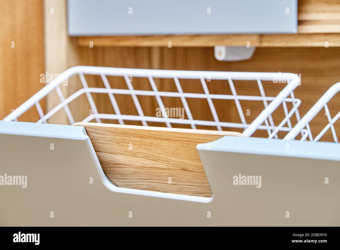 armadio moderno con cesto di bucato in mesh di metallo aperto. armadio in legno con ante per armadio a scomparsa. Mobili in legno compensato di quercia con luce Foto Stock