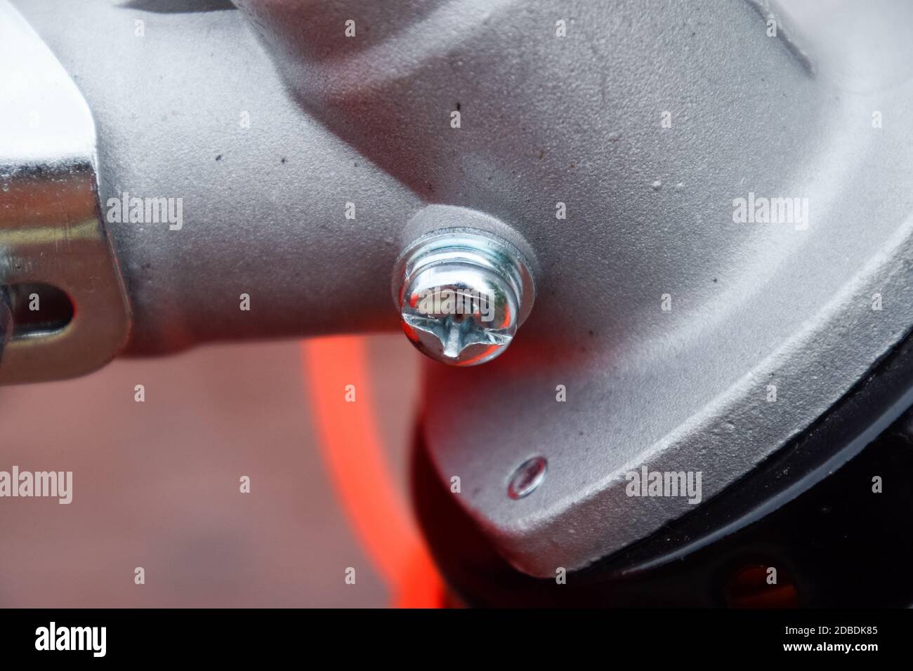 Dispositivi di fissaggio per la costruzione di trimmer a gas. Bulloni e viti sul corpo del trimero. Trimmer Gascosi con una foglia per falciare erba e arbusti. Foto Stock