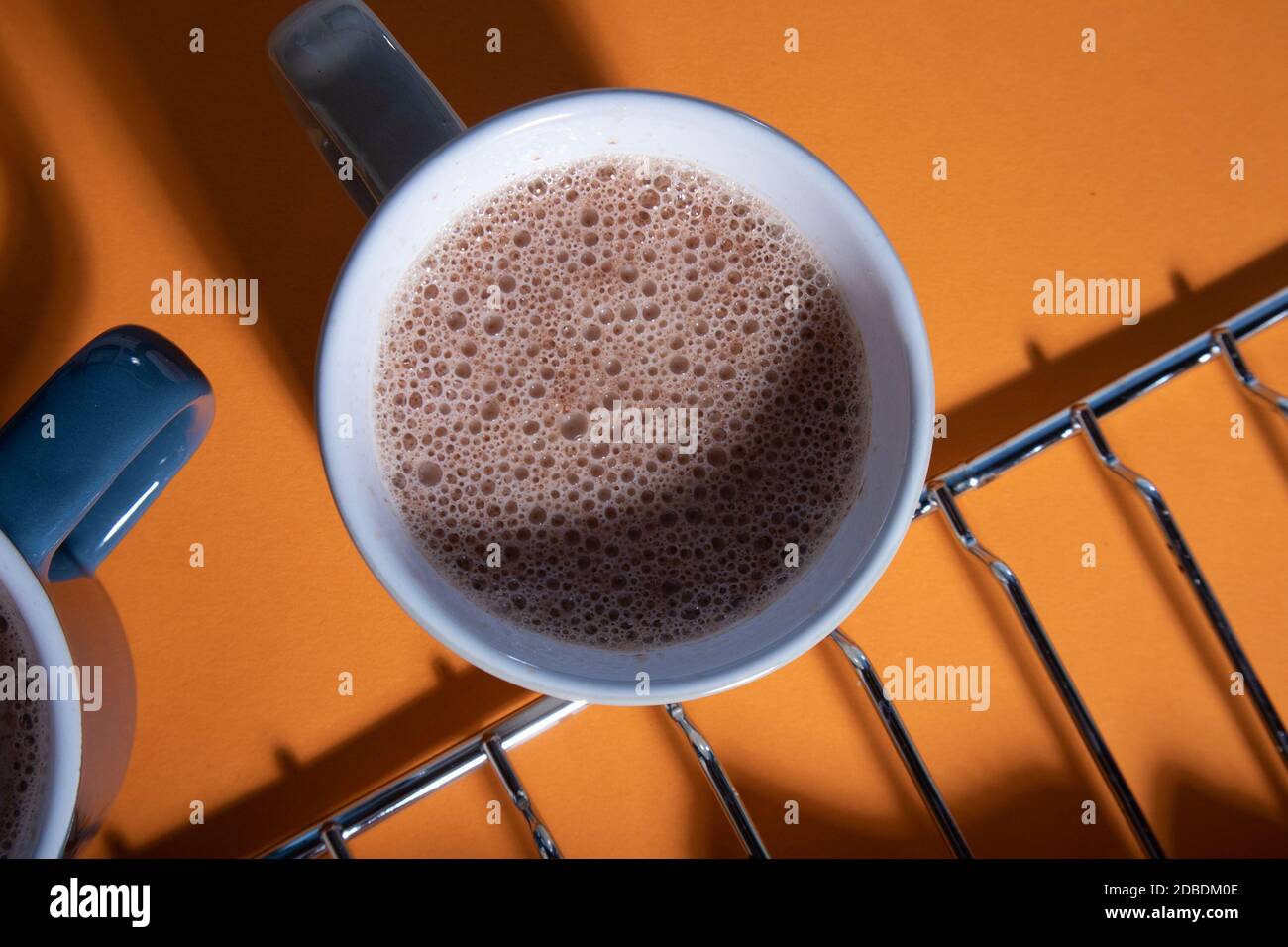 Vista dall'alto della tazza del mattino con cacao contro l'arancio luminoso sfondo Foto Stock