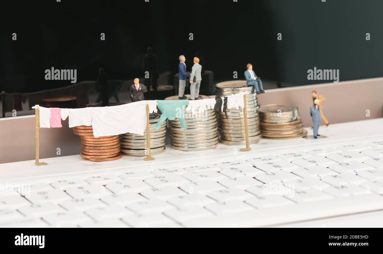 Riciclaggio di denaro con concetto di miniatura e monete Foto Stock