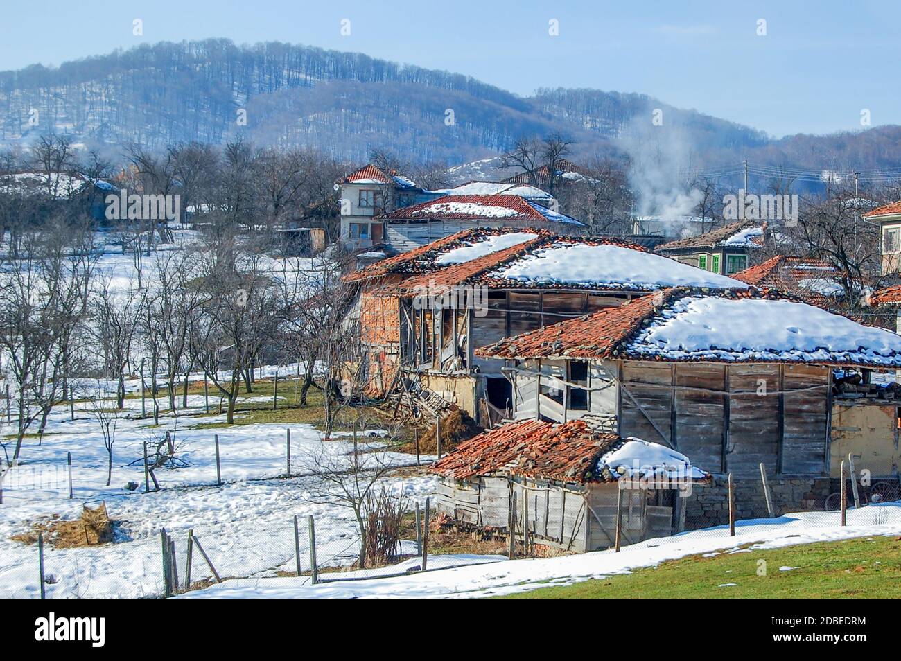 Paesaggio invernale in un povero villaggio di montagna, neve su tetti di case fatiscenti Foto Stock