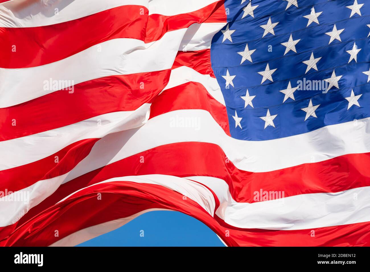Bandiera americana che oscilla nel vento su cielo blu, bandiera americana in primo piano, bandiera rossa bianca blu all'aperto alla luce del sole. Bandiera nazionale degli Stati Uniti d'America. Stelle e strisce degli Stati Uniti Foto Stock