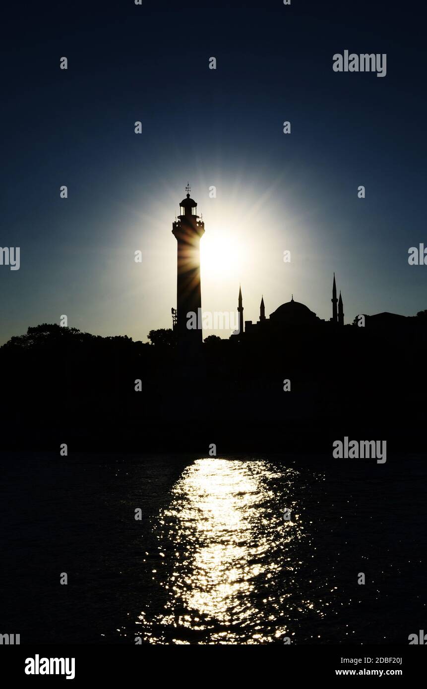Sagoma di una moschea al tramonto con il sole che si riflette sul fiume bosforo, Istanbul, Turchia Foto Stock