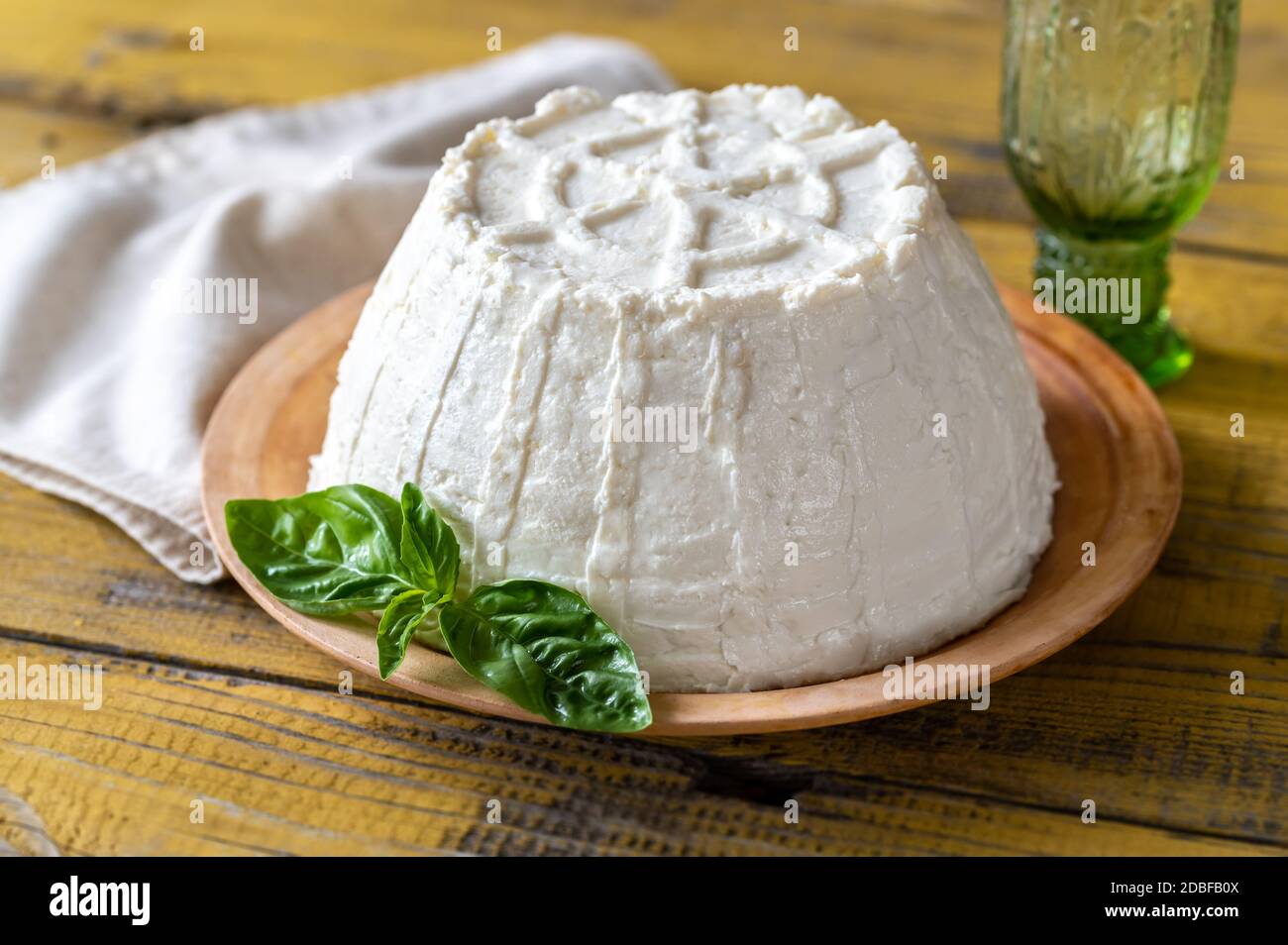 Ricotta un formaggio di siero di latte italiano con foglie di basilico fresco Foto Stock