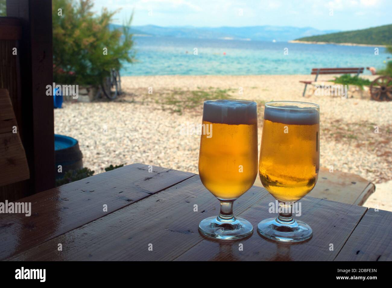 Due bicchieri di birra su un tavolo sulla spiaggia vicino al mare, Croazia Foto Stock