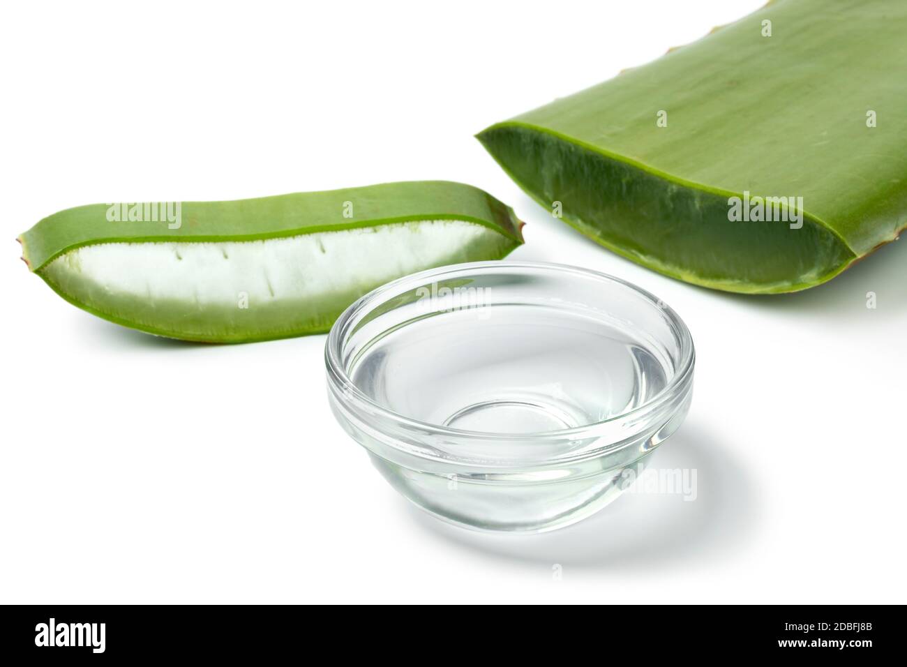 Foglia verde di aloe vera, fetta e una ciotola di vetro con gel su sfondo bianco primo piano Foto Stock
